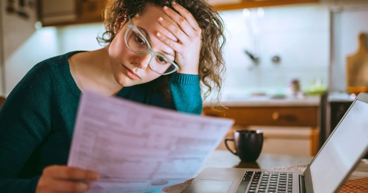 A split image showing the Federal Reserve building and a person looking worried at their financial statements